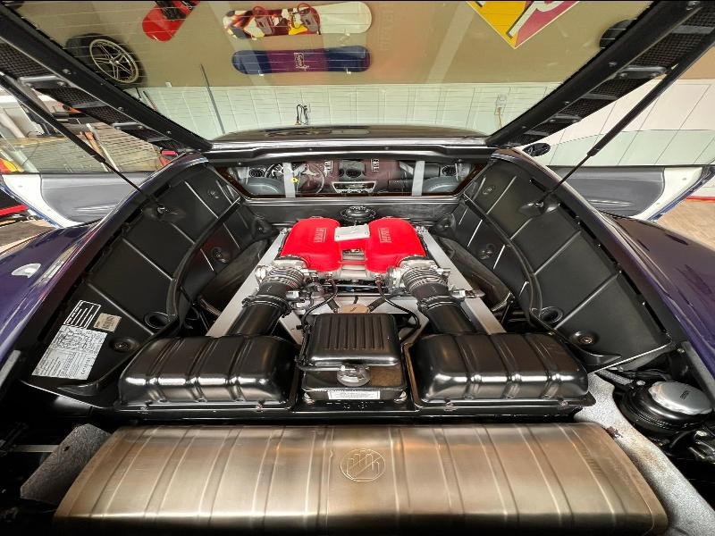 Engine bay of a Ferrari after thorough detailing and restoration, featuring a spotless clean with degreasing, surface restoration, and meticulous attention to every component for optimal performance and a like-new appearance