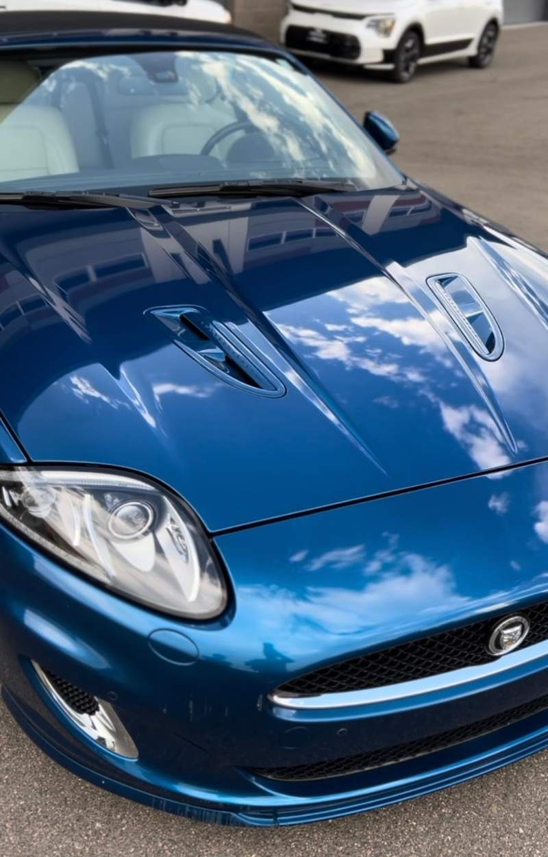 Incredible reflection on the blue Jaguar after expert paint correction and premium ceramic coating, showcasing a flawless, mirror-like finish with deep gloss and enhanced protection against scratches, contaminants, and water spots