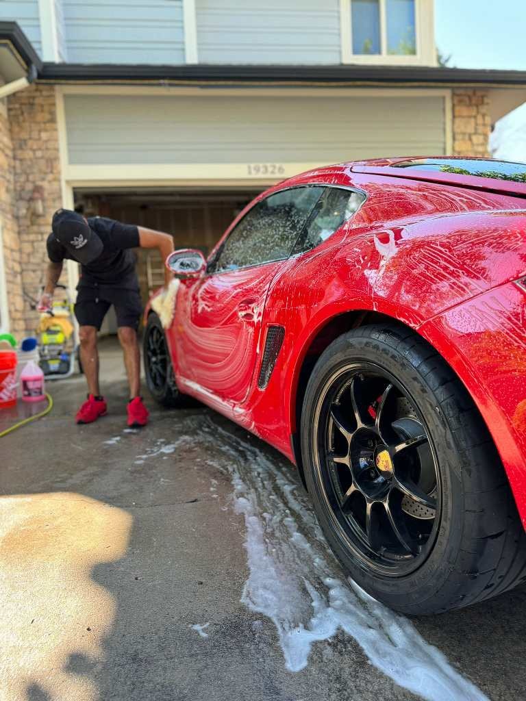 Red Porsche being detailed with a 3-step paint correction to eliminate imperfections, followed by a premium ceramic coating for enhanced protection, deep gloss, and long-lasting durability against scratches, water spots, and contaminants
